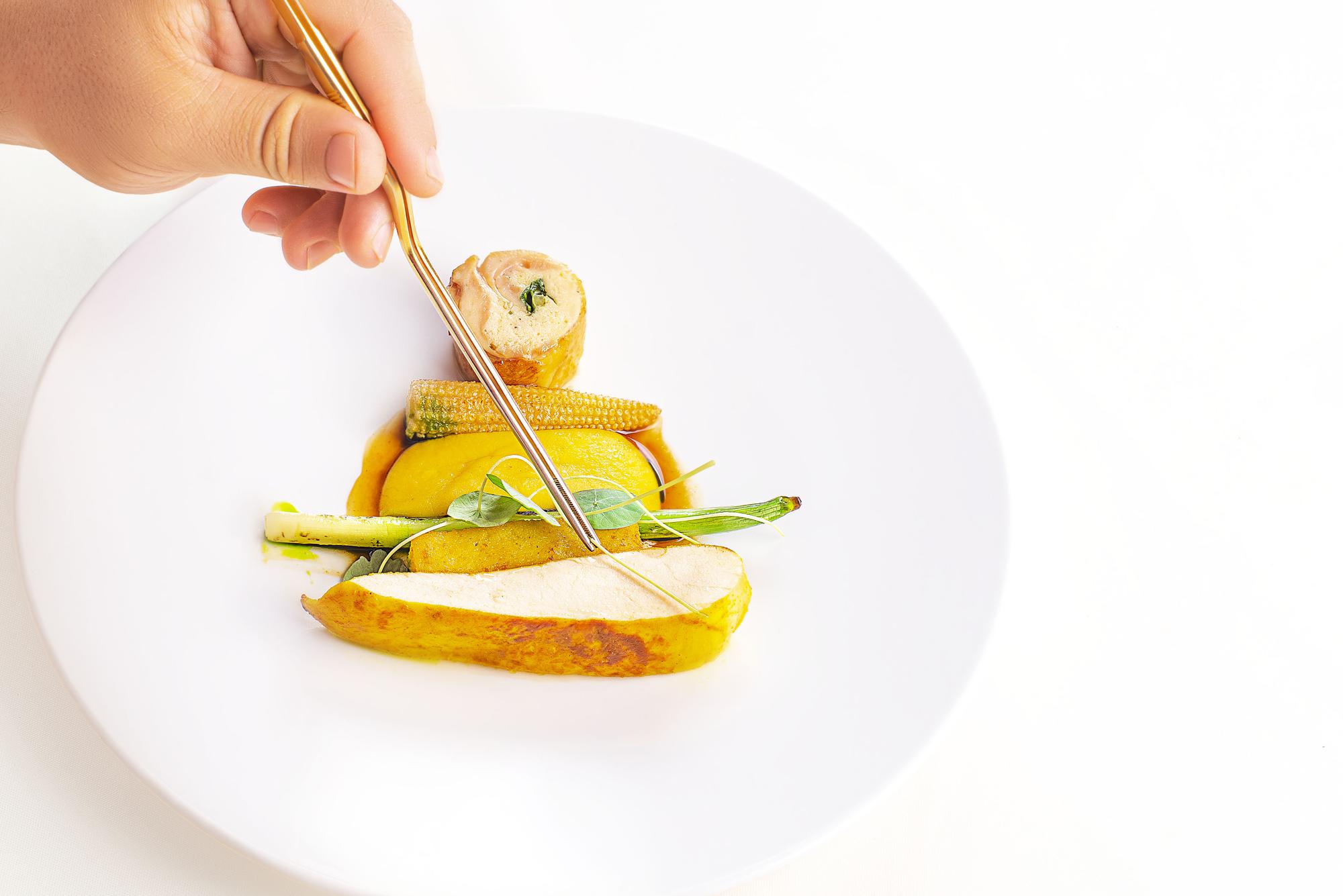 Chef finishing a plated seasonal dish